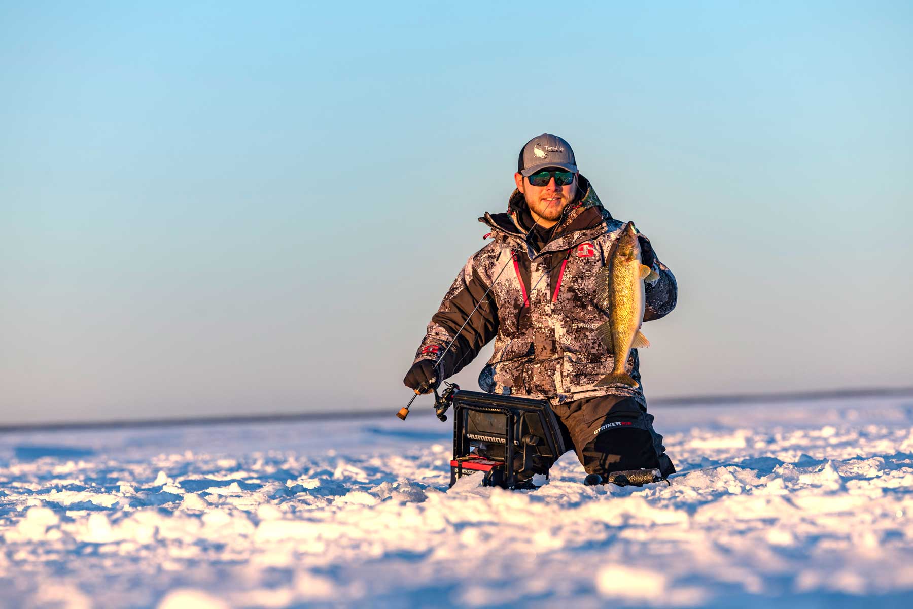 man with a tuned up custom ice fishing rod and a walleye